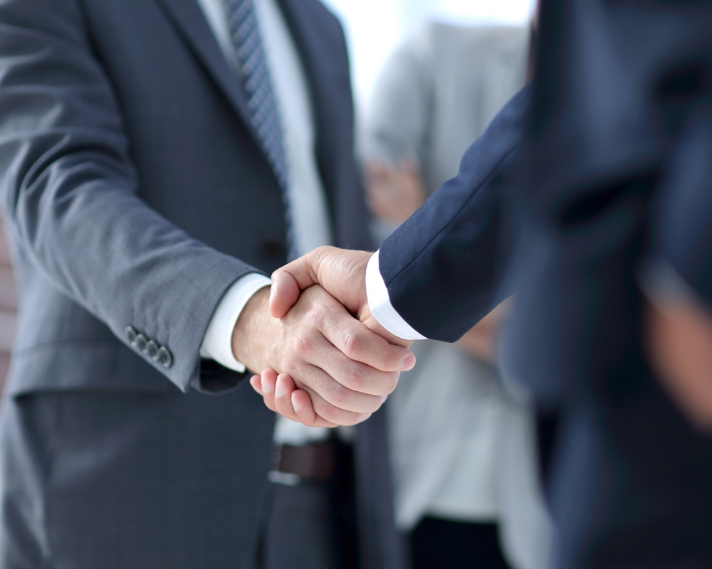 closeup of handshake of business partners on the background of business team